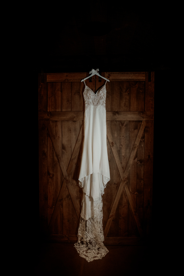 wedding dress hanging on barn door