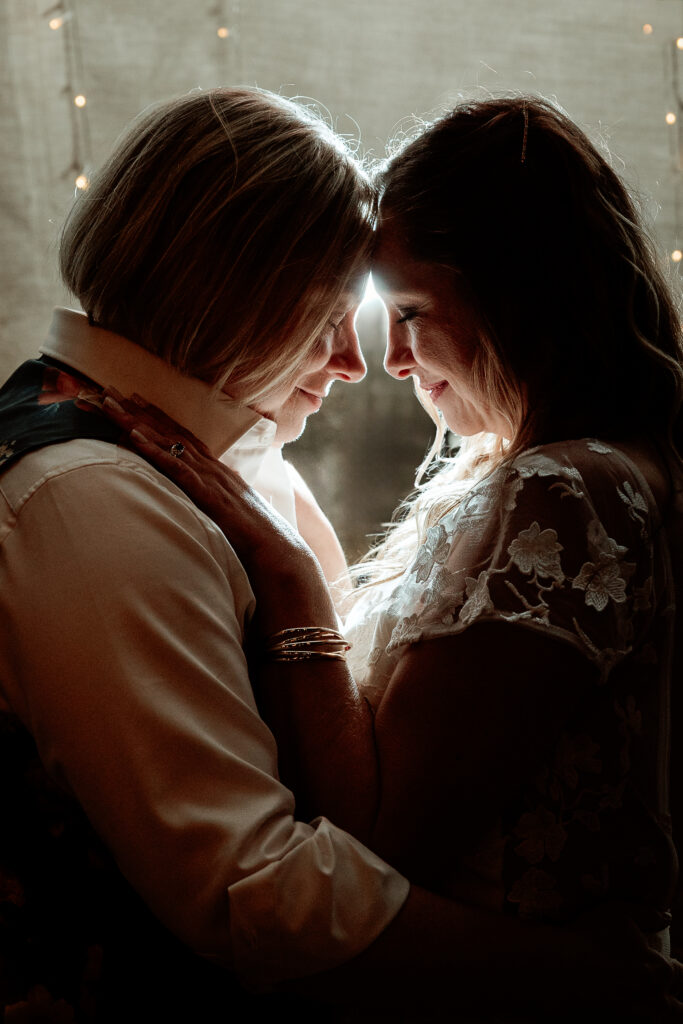 Two brides share a joyful moment during their wedding at the Old Schoolhouse in Merrimac, Wisconsin.