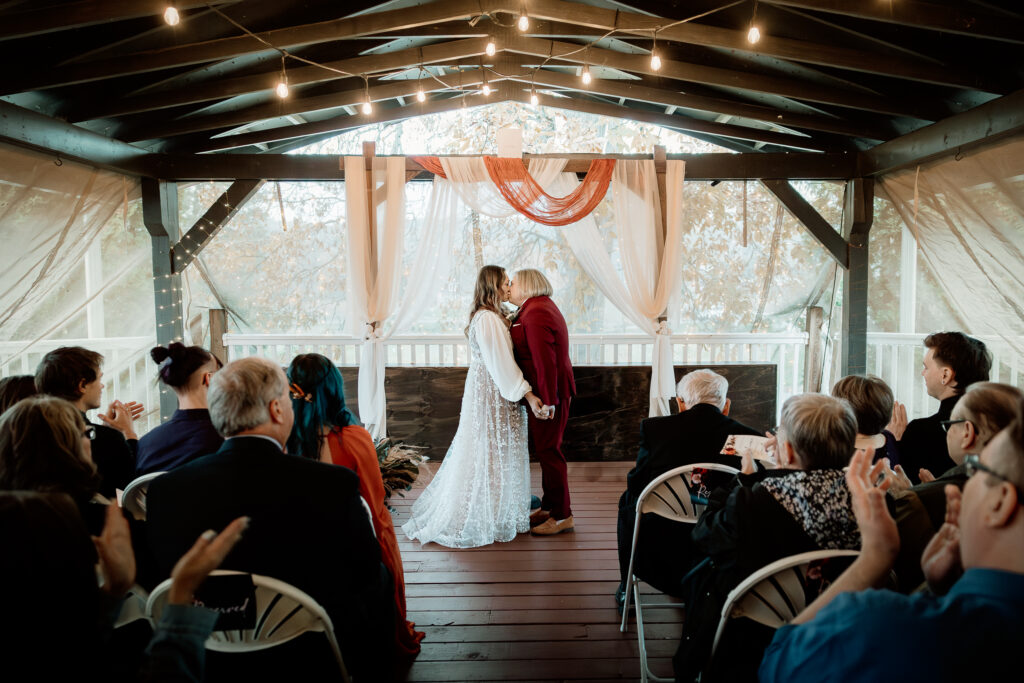 Two brides share a joyful moment during their wedding at the Old Schoolhouse in Merrimac, Wisconsin.