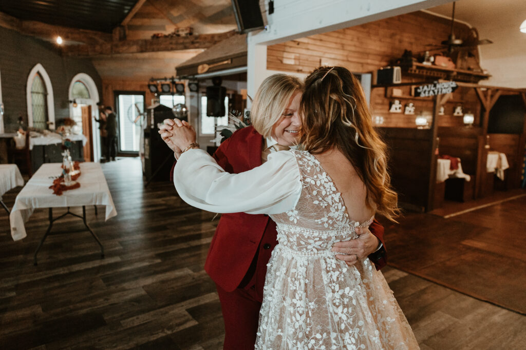 Two brides share a joyful moment during their wedding at the Old Schoolhouse in Merrimac, Wisconsin.