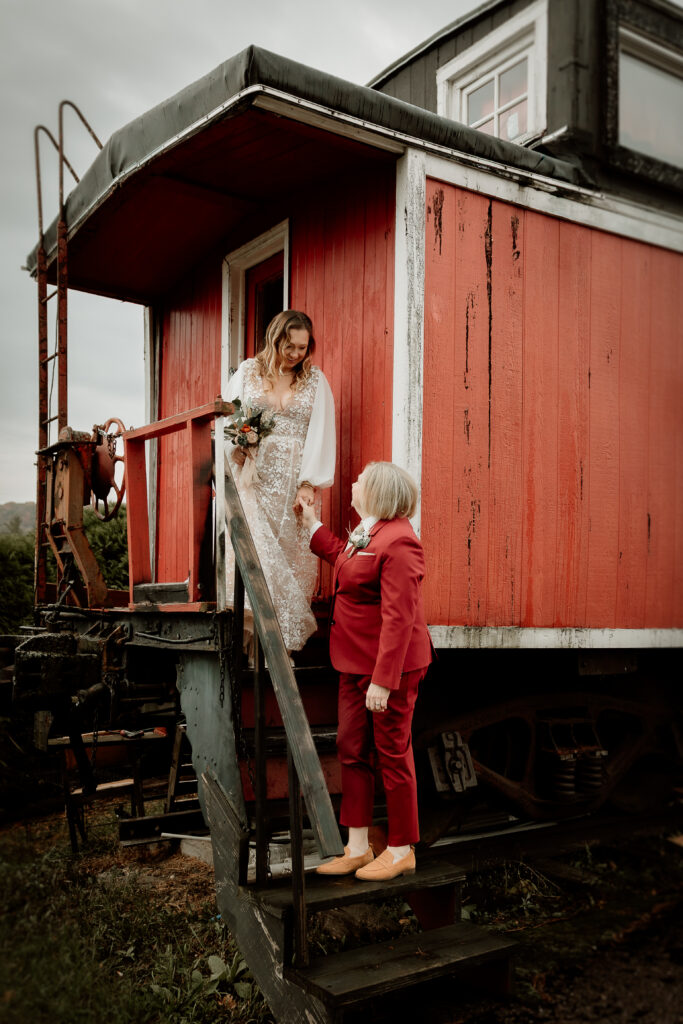 Two brides share a joyful moment during their wedding at the Old Schoolhouse in Merrimac, Wisconsin.