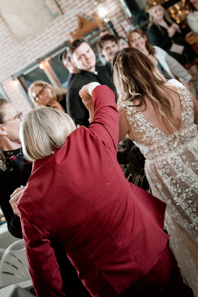 Two brides share a joyful moment during their wedding at the Old Schoolhouse in Merrimac, Wisconsin.