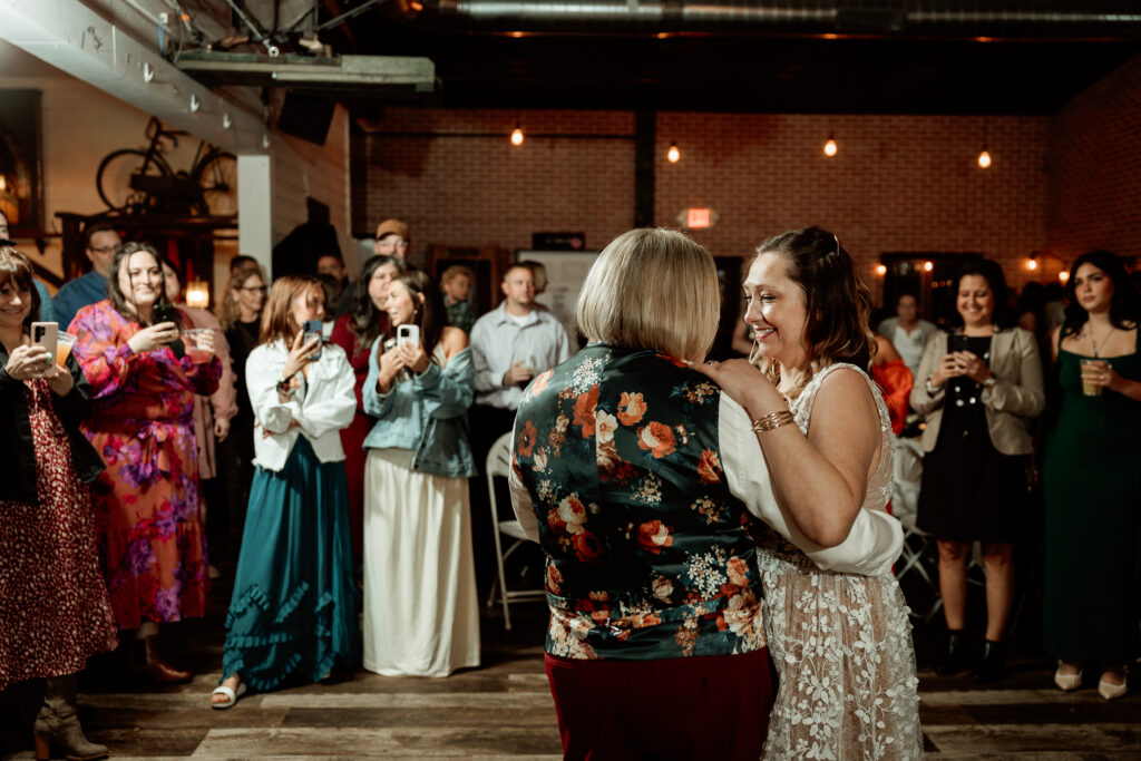 Two brides share a joyful moment during their wedding at the Old Schoolhouse in Merrimac, Wisconsin.