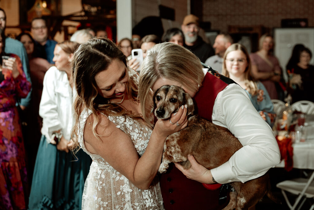 Two brides share a joyful moment during their wedding at the Old Schoolhouse in Merrimac, Wisconsin.