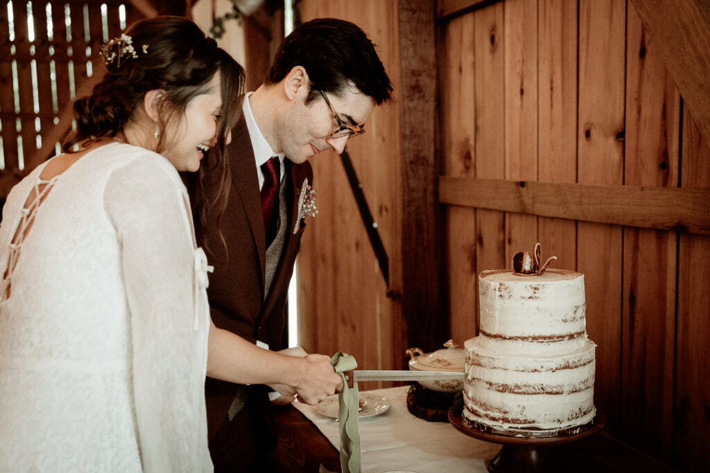 Bride and Groom's cake cutting during their reception at Burlap and Bells in Black River Falls, WI