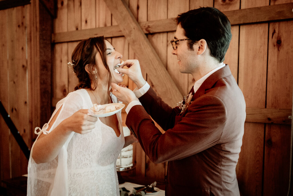 Bride and Groom's cake cutting during their reception at Burlap and Bells in Black River Falls, WI